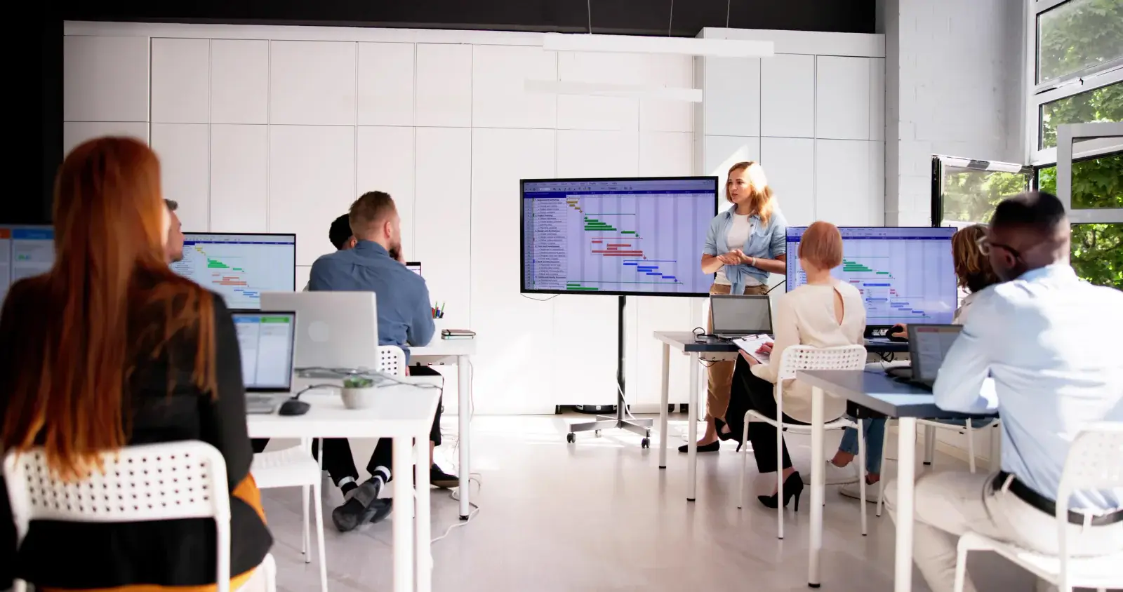 Instructor presenting to a workshop class with slides on the screen